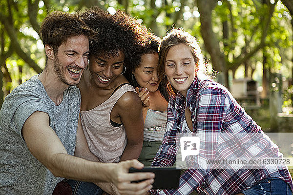 Glückliche junge Freunde nehmen Selfie auf Smartphone im Freien