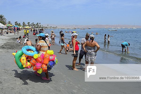 Strandverkäuferin mit bunten Schwimmreifen und Sandspielzeug  Paracas  Region Ica  Peru  Südamerika