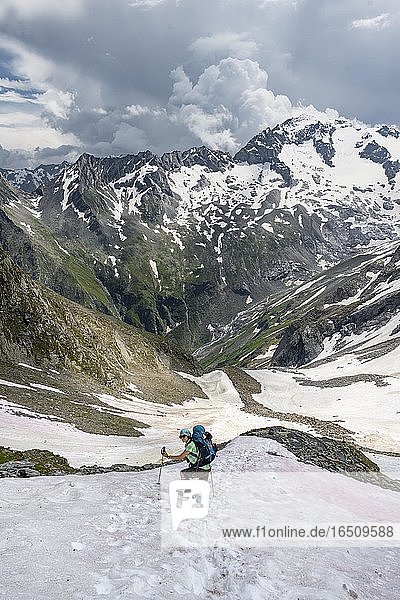 Wanderin überquert Schneefeld  Abstieg von der Mörchnerscharte zum Floitengrund  Berliner Höhenweg  Zillertaler Alpen  Zillertal  Tirol  Österreich  Europa