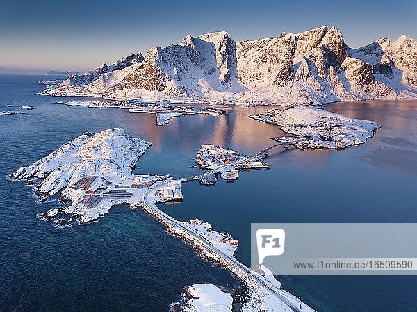 Luftaufnahme  Fjordlandschaft bei Sonnenaufgang  verschneite Berge im Winter  Fischerdorf Reine  Nordland  Lofoten  Norwegen  Europa
