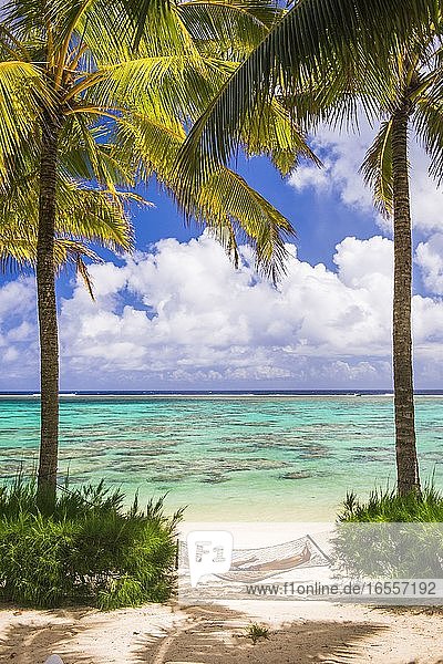 Frau entspannt sich in einer Hängematte unter Palmen am weißen Sandstrand auf der tropischen Insel Rarotonga  Cookinseln  Südpazifik