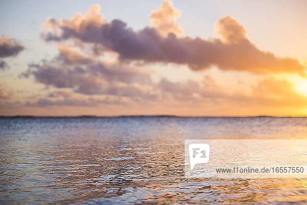 Tropischer Sonnenuntergang Hintergrund mit Kopie Raum zeigt dramatische Wolken am Himmel über einem Horizont des Pazifischen Ozeans  Rarotonga  Cook-Inseln