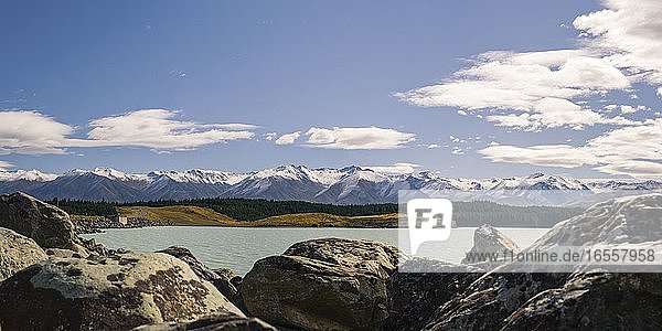 Panoramafoto von schneebedeckten Bergen und Lake Pukaki  Südinsel  Neuseeland. Dies ist ein Panoramafoto von schneebedeckten Bergen und dem eisblauen Wasser des Lake Pukaki im Aoraki Mount Cook National Park  Mackenzie District  Südinsel  Neuseeland. Das Landschaftsfoto wurde von einem Picknickplatz am Fuße des Lake Tekapo aus aufgenommen  von dem aus man eine großartige Aussicht über die gesamte Länge des Sees bis zum Mount Cook in der Ferne hat.