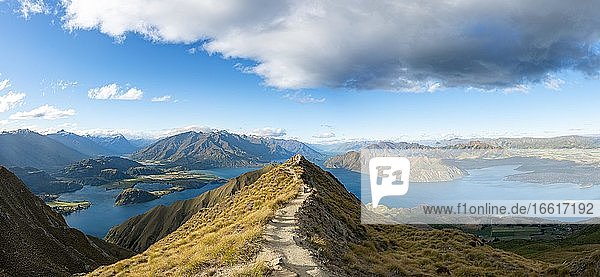 Hiker on a ridge  view of mountains and lake from Mount Roy  Roys Peak  Lake Wanaka  Southern Alps  Otago  South Island  New Zealand  Oceania