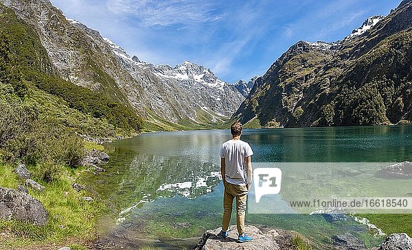 Wanderer steht am Ufer  Lake Marian  Fiordland Nationalpark  Te Anau  Southland  Südinsel  Neuseeland  Ozeanien
