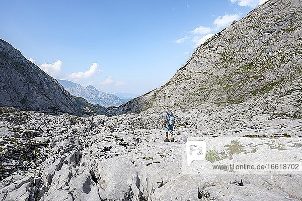 Wanderer in einer Landschaft aus ausgewaschenen Karststeinfelsen  Funtenseetauern  Steinernes Meer  Nationalpark Berchtesgaden  Berchtesgadener Land  Oberbayern  Bayern  Deutschland  Europa