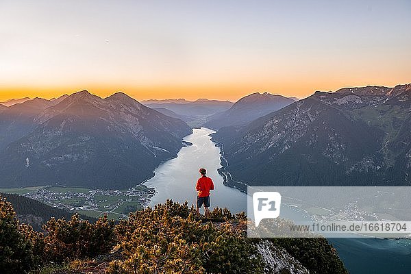 Sunset  young man looking over mountain landscape  view from the top of the Bärenkopf to the Achensee  left Seebergspitze and Seekarspitze  right Rofangebirge  Tyrol  Austria  Europe