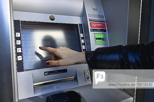 Frau tippt am Touchscreen eines Geldautomaten einer Sparkasse  Waiblingen  Baden-Württemberg  Deutschland  Europa