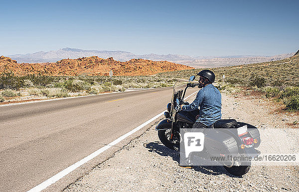 Man riding motorcycle during road trip in summer  Nevada  USA