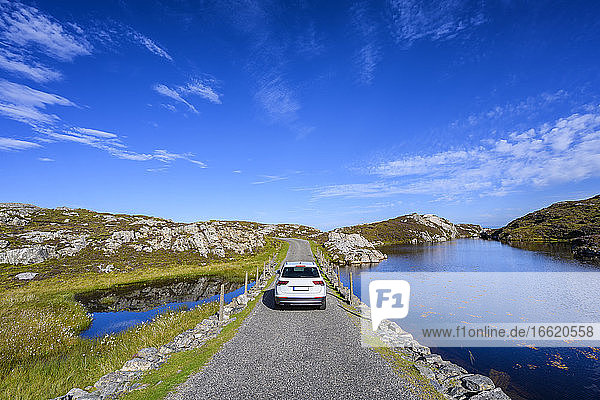 Car driving along Golden Road on Isle of Harris