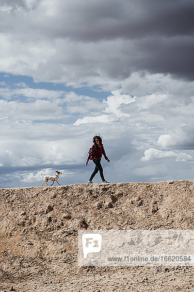 Spain  Navarre  Young woman hiking with dog in Bardenas Reales