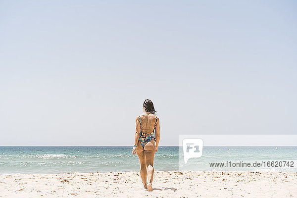 Frau im Bodysuit beim Spaziergang am Strand von Valdevaqueros in Tarifa  Spanien