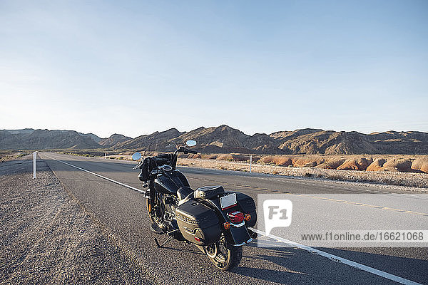 Motorrad auf Wüstenstraße gegen den Himmel geparkt  Nevada  USA
