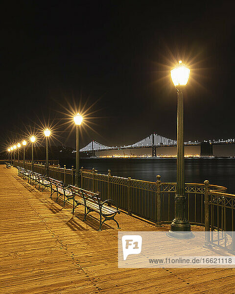 Street light on pier with Oakland Bay Bridge in background at San Francisco  California  USA