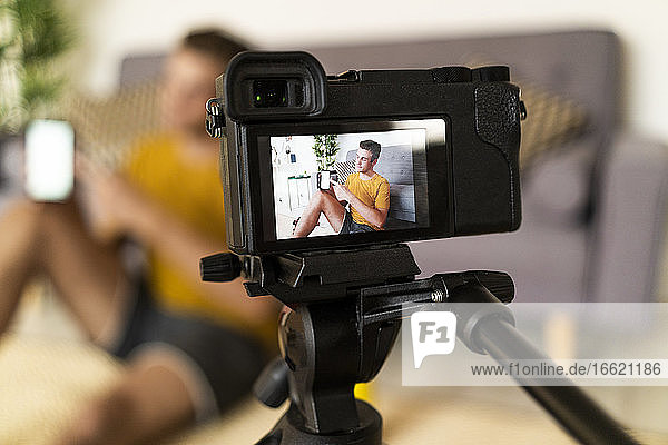 Personal trainer recording fitness in camera while sitting at home