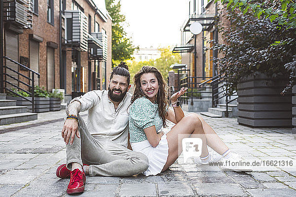 Glückliches Paar sitzt auf der Straße in der Stadt