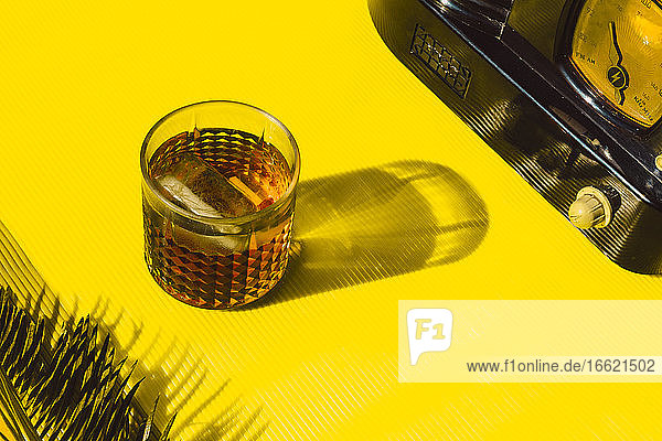 High angle view of cocktail liquor and old radio on table