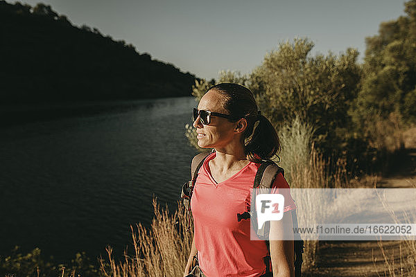 Frau bewundert den Blick auf den Fluss  während sie in der Sierra De Hornachuelos steht  Cordoba  Spanien