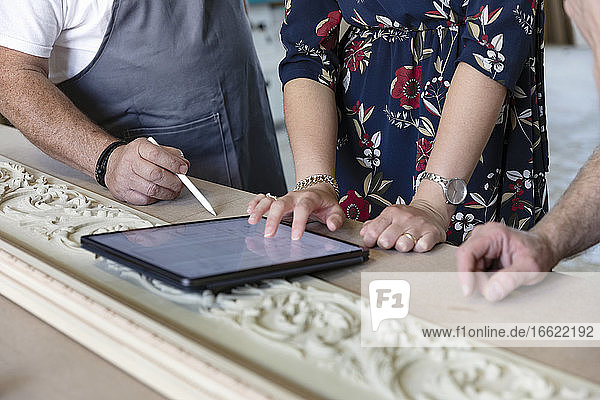 Schreiner und Designer verwenden ein digitales Tablet in der Werkstatt