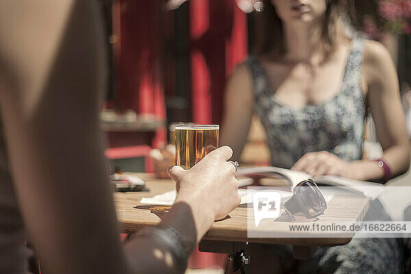 Woman having beer with female friend at pub