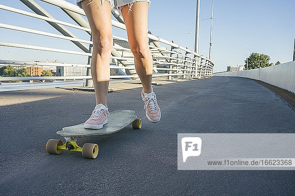 Legs of woman skating on street during sunny day