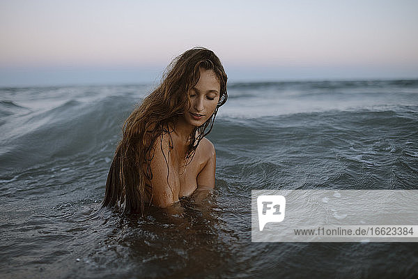 Junge Frau genießt im Wasser am Strand