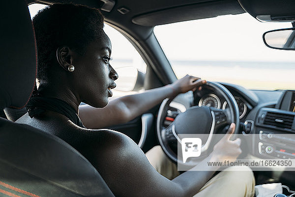 Beautiful woman looking away while driving car