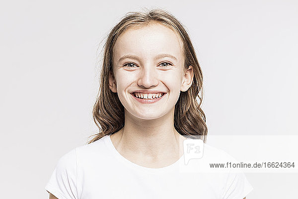 Nahaufnahme eines niedlichen lächelnden Mädchens vor weißem Hintergrund