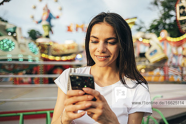 Close-up of beautiful woman using mobile phone at amusement park