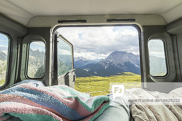 Male tourist relaxing in campervan against mountain range  Sesto Dolomites  Dolomites  Alto Adige  Italy