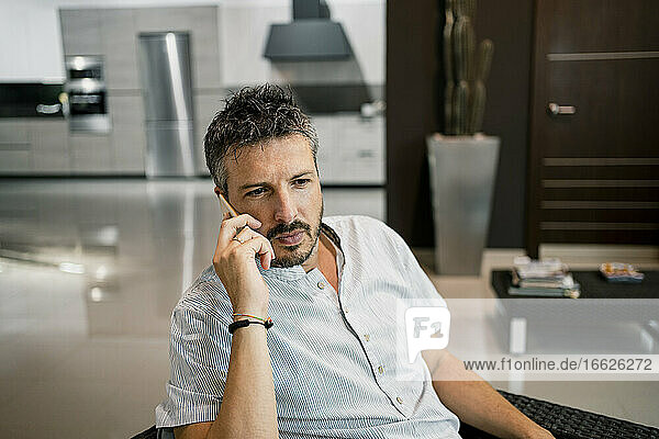 Handsome businessman talking on smart phone while working at office