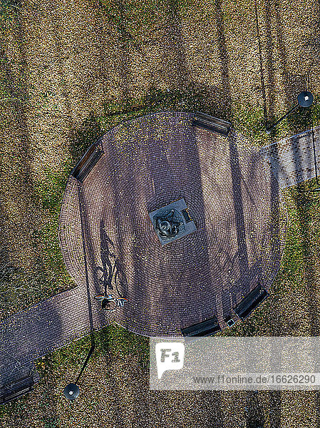 Russland  Moskauer Gebiet  Sergijew Posad  Luftaufnahme einer Radfahrerin  die am Denkmal für Michail Prischwin im Herbstpark vorbeifährt
