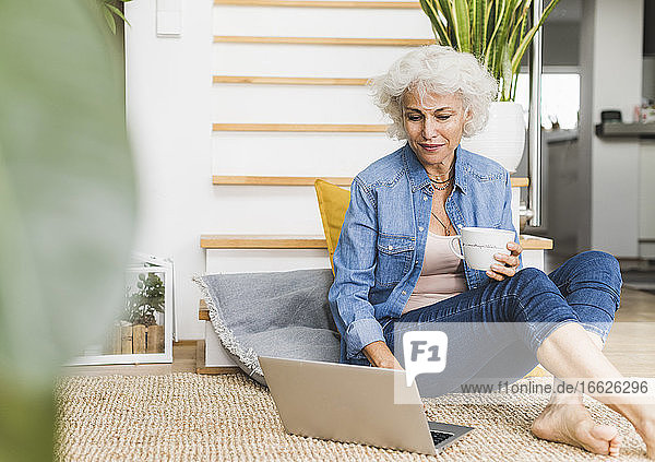 Mature woman working on laptop while sitting at home