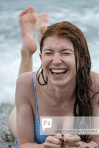 Beautiful young woman wearing bikini lying on beach
