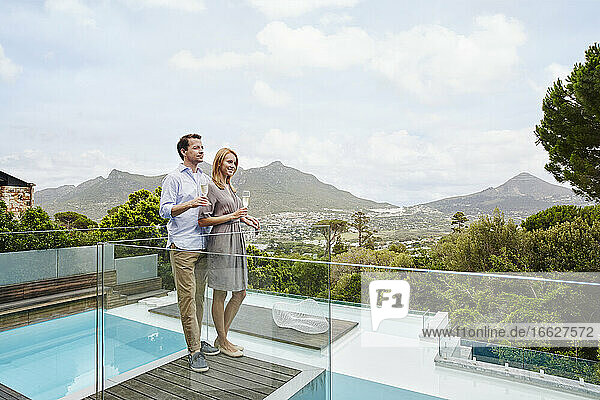 Paar hält Weinglas  während es auf dem Balkon steht