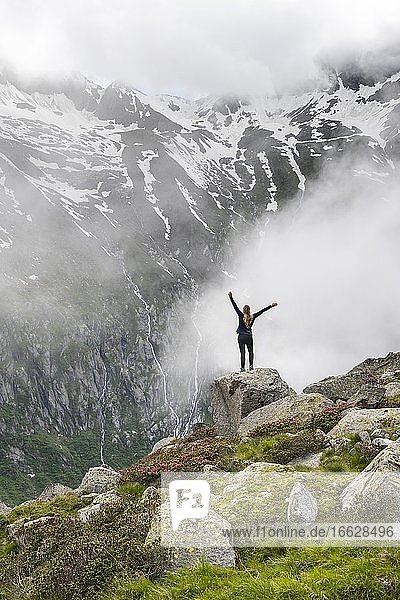 Berglandschaft bei Nebel  Wanderin streckt Arme in die Luft  nahe Furtschaglhaus  Berliner Höhenweg  Zillertaler Alpen  Zillertal  Tirol  Österreich  Europa