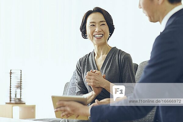 Japanische Frau mittleren Alters  die im Zimmer lächelt