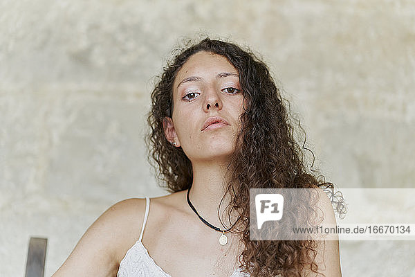 Portrait of curly haired young woman with serious look