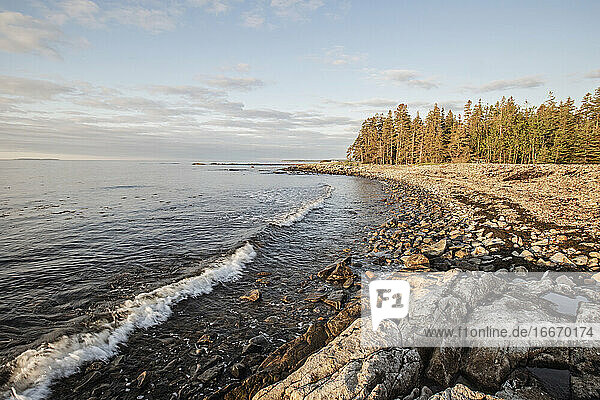 Waves lap against rocky coast at sunrise  Acadia National Park  Maine