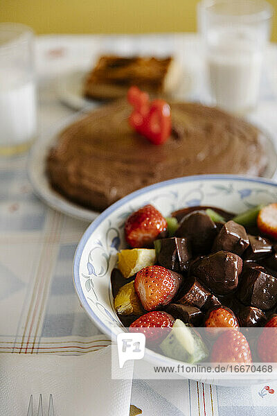 Leckere Früchte und Schokolade auf dem Tisch mit Geburtstagskuchen