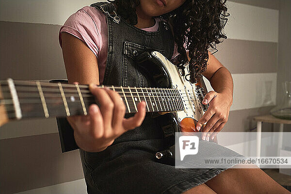 Nahaufnahme eines Mädchens beim Spielen der E-Gitarre