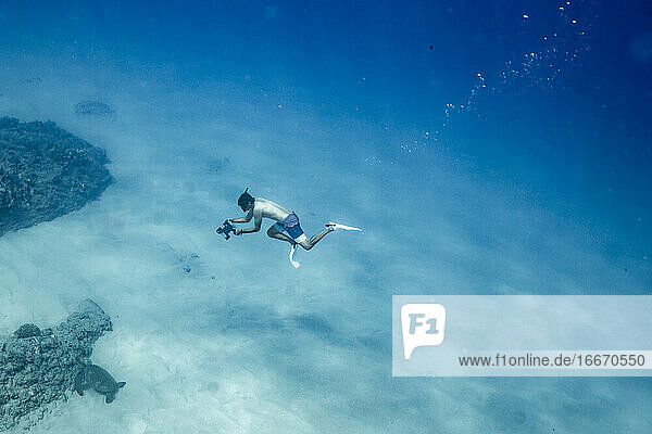 Unterwasserfotograf taucht auf Hawaii frei auf den Meeresboden