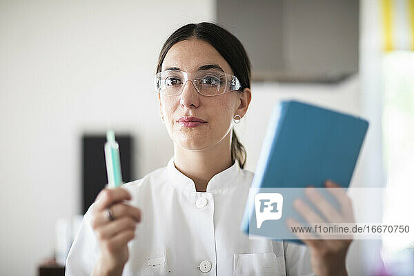 Wissenschaftlerin mit Laborbrille  Tablette und Probe in einem Labor