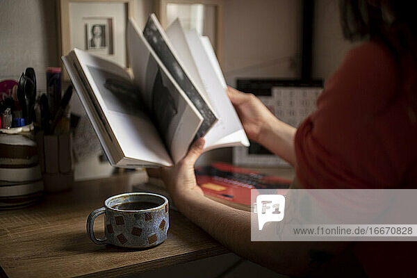 Junge Frau studiert mit einer Tasse Kaffee