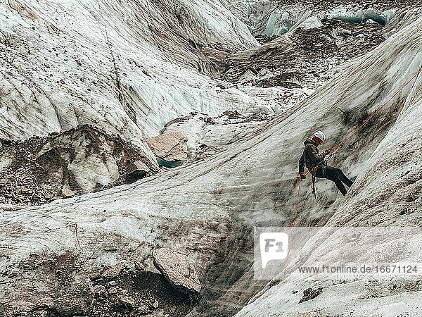 Close Shot of mountaineer rappelling on glacier in European Alps
