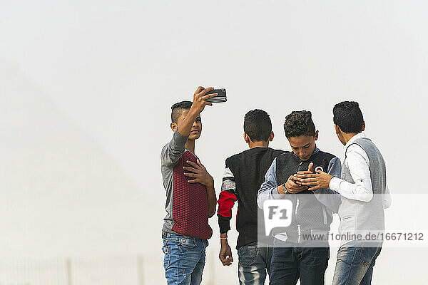 A group of Egyptian boys outside on their phones