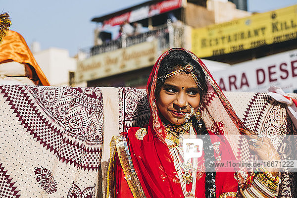 Junge Inderin in rotem  farbenfrohem Saree beim Wüstenfest in Jaisalmer