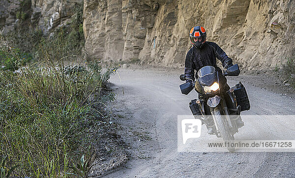 Mann fährt Tourenmotorrad auf unbefestigter Straße  Santa Teresa  Piura  Peru