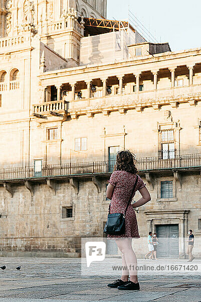 Young woman looking away while standing in old town square