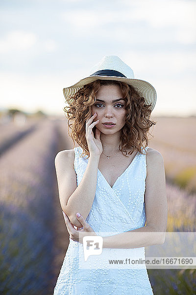 curly-haired woman with a hat outdoors